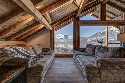 a living room with couches and a large window at Chalet Chèvrefeuille in Saint-Gervais-les-Bains