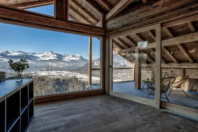 a room with a large window with a table and chairs at Chalet Chèvrefeuille in Saint-Gervais-les-Bains