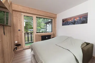 a bedroom with a bed and a large window at Charmant Studio tout confort au Brévent-Chamonix in Chamonix-Mont-Blanc