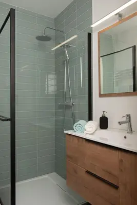 a bathroom with a shower with a sink and a mirror at Charmant Studio tout confort au Brévent-Chamonix in Chamonix-Mont-Blanc