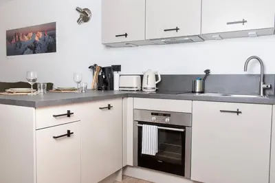 a kitchen with white cabinets and a sink at Charmant Studio tout confort au Brévent-Chamonix in Chamonix-Mont-Blanc
