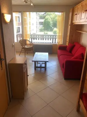 a living room with a red couch and a table at Studio Les Carroz in Les Carroz d'Araches