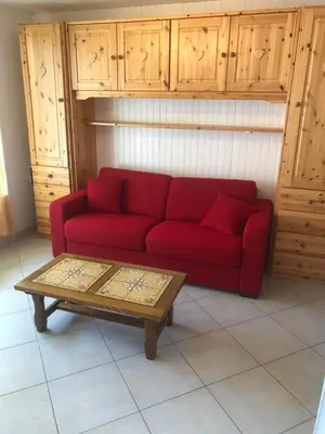 a red couch in a living room with a coffee table at Studio Les Carroz in Les Carroz d'Araches