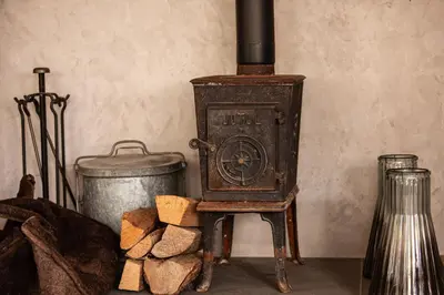 an old wood stove with a pot and fire wood at Chalet Kaiya - Alpes Travel - Les Praz - sleeps 8 in Chamonix-Mont-Blanc