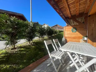 a table and chairs on the porch of a house at Charmant T3 Neuf, Skibus Gratuit, Terrasse, 2 Places Privées, WIFI - Samoëns - FR-1-624-122 in Samoëns