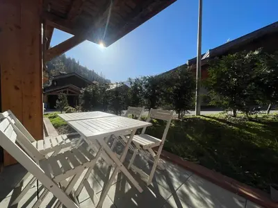 a white table and chairs on a porch with a view at Charmant T3 Neuf, Skibus Gratuit, Terrasse, 2 Places Privées, WIFI - Samoëns - FR-1-624-122 in Samoëns