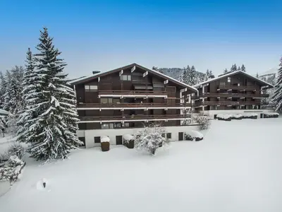 a large building in the snow with snow covered trees at Charmant appartement 2 chambres avec cheminée et parking à Megève - FR-1-453-254 in Megève