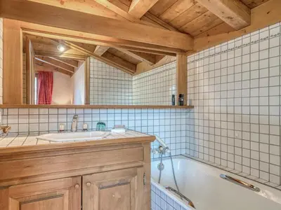 a bathroom with a tub and a sink and a mirror at Charmant appartement 2 chambres à Megève avec Wifi et parking - FR-1-453-292 in Megève
