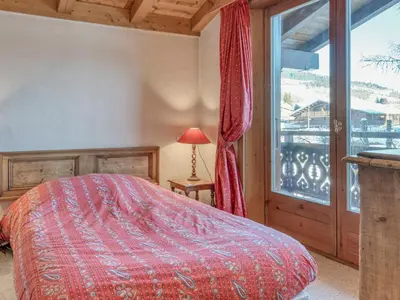 a bedroom with a bed and a large window at Charmant appartement 2 chambres à Megève avec Wifi et parking - FR-1-453-292 in Megève