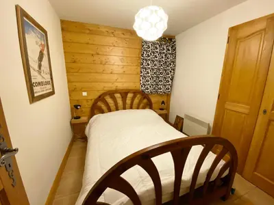 a small bedroom with a bed and a chandelier at Charmant appartement 4 pièces 8 pers., ski au pied, animaux acceptés, wifi à Morillon - FR-1-815-86 in Morillon