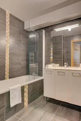 a bathroom with a tub and a sink and a mirror at Apartment Aiguille de Chamonix- Alpes Travel - Central Chamonix (sleeps 4) in Chamonix-Mont-Blanc