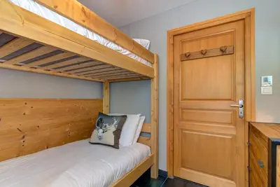 a bedroom with two bunk beds and a door at Apartment Aiguille de Chamonix- Alpes Travel - Central Chamonix (sleeps 4) in Chamonix-Mont-Blanc