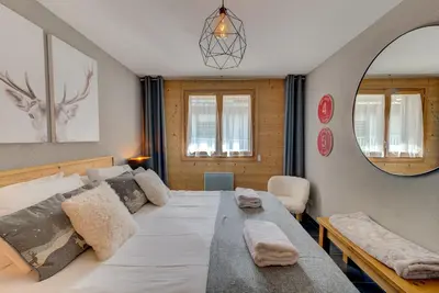 a bedroom with a large bed and a mirror at Apartment Aiguille de Chamonix- Alpes Travel - Central Chamonix (sleeps 4) in Chamonix-Mont-Blanc