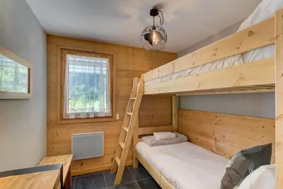 a bedroom with two bunk beds and a window at Apartment Aiguille de Chamonix- Alpes Travel - Central Chamonix (sleeps 4) in Chamonix-Mont-Blanc