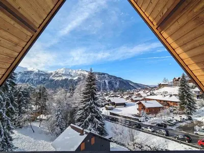 a view of a snowy mountain from a window at Studio 4 pers avec balcon, près des remontées mécaniques - FR-1-572-149 in Arâches-la-Frasse