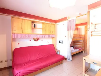 a red couch in a room with a bedroom at Studio 4 pers avec balcon, proche pistes et commerces, centre village - FR-1-572-165 in Arâches-la-Frasse