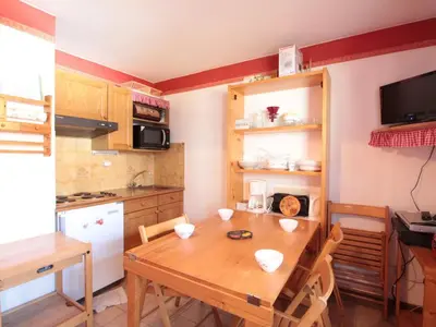 a kitchen with a wooden table with chairs and a table and a kitchen at Studio 4 pers avec balcon, proche pistes et commerces, centre village - FR-1-572-165 in Arâches-la-Frasse