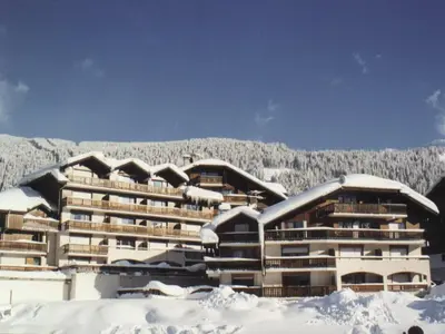 a building covered in snow with a mountain in the background at Studio 4 pers avec balcon, proche pistes et commerces, centre village - FR-1-572-165 in Arâches-la-Frasse