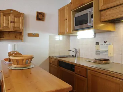 a kitchen with wooden cabinets and a sink and a microwave at Studio spacieux 4 pers avec parking et lave-vaisselle - FR-1-572-93 in Arâches-la-Frasse