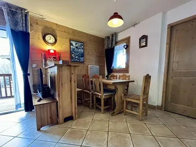 a kitchen with a table and chairs and a clock at Appartement 3 pièces avec garage, terrasse, proche pistes et commerces à Arâches-la-Frasse - FR-1-572-250 in Arâches-la-Frasse