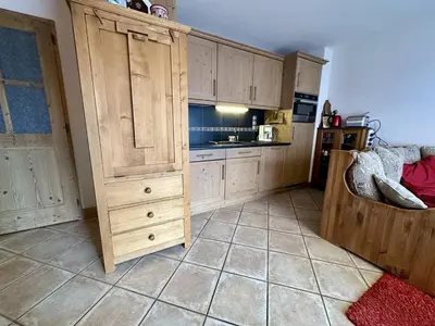 a kitchen with a large wooden cabinet in a room at Appartement 3 pièces avec garage, terrasse, proche pistes et commerces à Arâches-la-Frasse - FR-1-572-250 in Arâches-la-Frasse