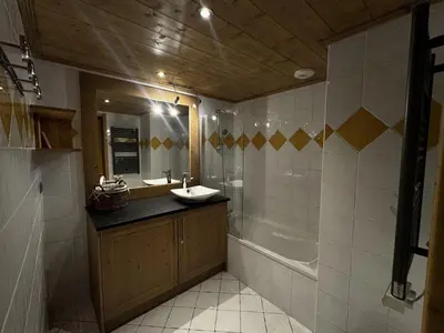 a bathroom with a sink and a tub and a mirror at Appartement cosy 6 personnes avec garage, terrasse et wifi au cœur du village, proche pistes et commerces - FR-1-572-251 in Arâches-la-Frasse