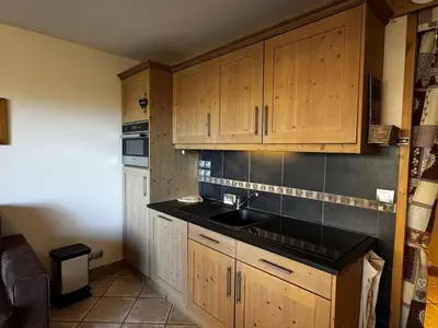 a kitchen with wooden cabinets and a sink at Appartement cosy 6 personnes avec garage, terrasse et wifi au cœur du village, proche pistes et commerces - FR-1-572-251 in Arâches-la-Frasse