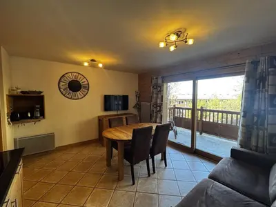a kitchen and dining room with a table and a balcony at Appartement cosy 6 personnes avec garage, terrasse et wifi au cœur du village, proche pistes et commerces - FR-1-572-251 in Arâches-la-Frasse