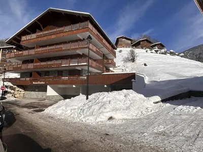 a building with a pile of snow in front of it at Appartement cosy 6 personnes avec garage, terrasse et wifi au cœur du village, proche pistes et commerces - FR-1-572-251 in Arâches-la-Frasse