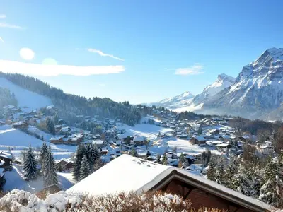 a village covered in snow with mountains in the background at Appartement cosy 6 personnes avec garage, terrasse et wifi au cœur du village, proche pistes et commerces - FR-1-572-251 in Arâches-la-Frasse