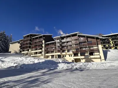 a large apartment building with snow in front of it at Studio aux Carroz 4 pers, balcon, proche commerces et pistes - FR-1-572-254 in Arâches-la-Frasse