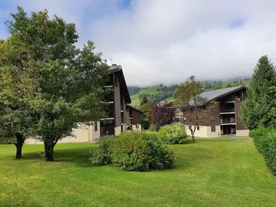 a large building with a tree in a yard at Mountain RoomChaleureux - Accueillant & Convivial in Demi-Quartier