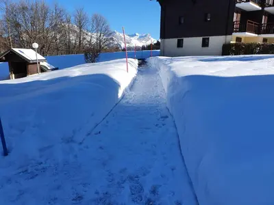 a snow covered street with a snow covered wall at Mountain RoomChaleureux - Accueillant & Convivial in Demi-Quartier