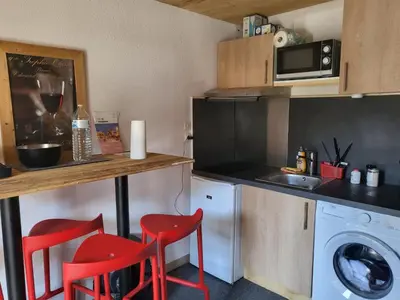 a kitchen with red chairs and a counter and a sink at Mountain RoomChaleureux - Accueillant & Convivial in Demi-Quartier