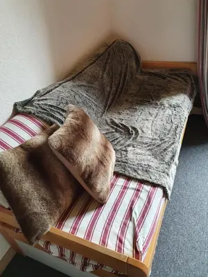 a bed with brown blankets on top of it at Mountain RoomChaleureux - Accueillant & Convivial in Demi-Quartier