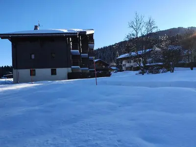 a snow covered field with a building in the background at Mountain RoomChaleureux - Accueillant & Convivial in Demi-Quartier