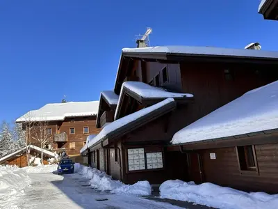 a building covered in snow with a car parked next to it at Appartement 3 pièces pour 6 pers, bien équipé, face au spa et ski bus, proche pistes et commerces - FR-1-572-10 in Arâches-la-Frasse