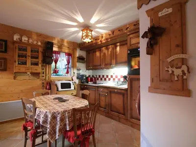 a kitchen with a table and a kitchen with wooden cabinets at Appartement 3 pièces pour 6 pers, bien équipé, face au spa et ski bus, proche pistes et commerces - FR-1-572-10 in Arâches-la-Frasse