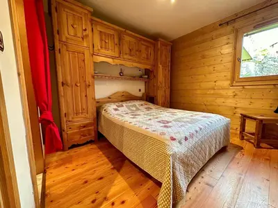 a bedroom with a bed in a wooden room at 3 pièces, 6 pers, animaux admis, parking, vue sur piscine - FR-1-572-5 in Arâches-la-Frasse
