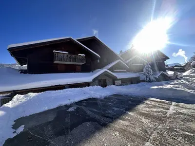 a house covered in snow with the sun behind it at 3 pièces, 6 pers, animaux admis, parking, vue sur piscine - FR-1-572-5 in Arâches-la-Frasse