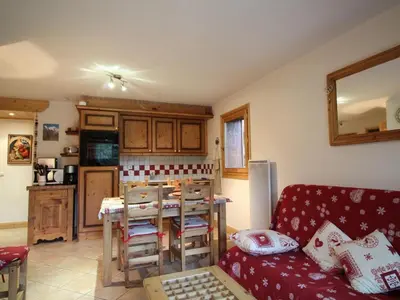 a living room with a couch and a kitchen at 3 pièces, 6 pers, animaux admis, parking, vue sur piscine - FR-1-572-5 in Arâches-la-Frasse