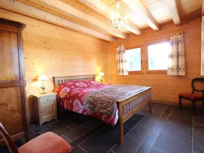 a bedroom with a bed in a wooden cabin at Chalet cosy 12 pers. à 1km des pistes, 5 ch., WiFi, cheminée, abri voiture - FR-1-572-30 in Arâches-la-Frasse