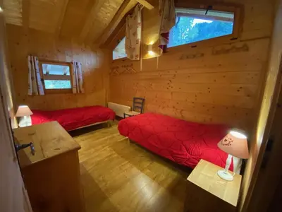a room with two beds in a log cabin at Chalet cosy 12 pers. à 1km des pistes, 5 ch., WiFi, cheminée, abri voiture - FR-1-572-30 in Arâches-la-Frasse
