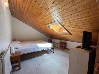 a bedroom with a bed and a wooden ceiling at Charmant studio duplex rénové, 4/5 pers, garage, proche centre, pistes et commerces. - FR-1-572-60 in Arâches-la-Frasse