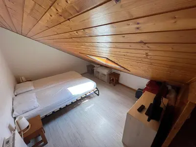 an attic room with a bed and a wooden ceiling at Charmant studio duplex rénové, 4/5 pers, garage, proche centre, pistes et commerces. - FR-1-572-60 in Arâches-la-Frasse