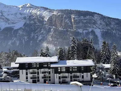a building in front of a snow covered mountain at Studio pour 6 pers avec sdd rénovée et parking, sur les pistes - FR-1-572-80 in Arâches-la-Frasse