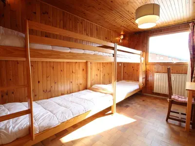 two bunk beds in a wooden room with a window at Spacieux 3 pièces au centre d'Arâches-la-Frasse, 6 pers., proche pistes et commerces - FR-1-572-69 in Arâches-la-Frasse