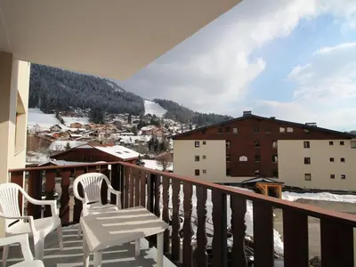 a balcony with two chairs and a view of a city at Spacieux 3 pièces au centre d'Arâches-la-Frasse, 6 pers., proche pistes et commerces - FR-1-572-69 in Arâches-la-Frasse