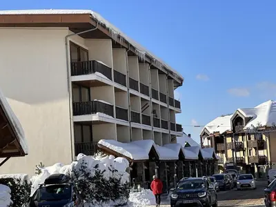 a snow covered building with cars parked in a parking lot at Spacieux 3 pièces au centre d'Arâches-la-Frasse, 6 pers., proche pistes et commerces - FR-1-572-69 in Arâches-la-Frasse