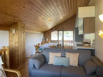 a living room with a blue couch and a kitchen at Duplex lumineux 3 pièces, 7 pers, 3 balcons, proche pistes et commerces, parking, ski bus - FR-1-572-72 in Arâches-la-Frasse